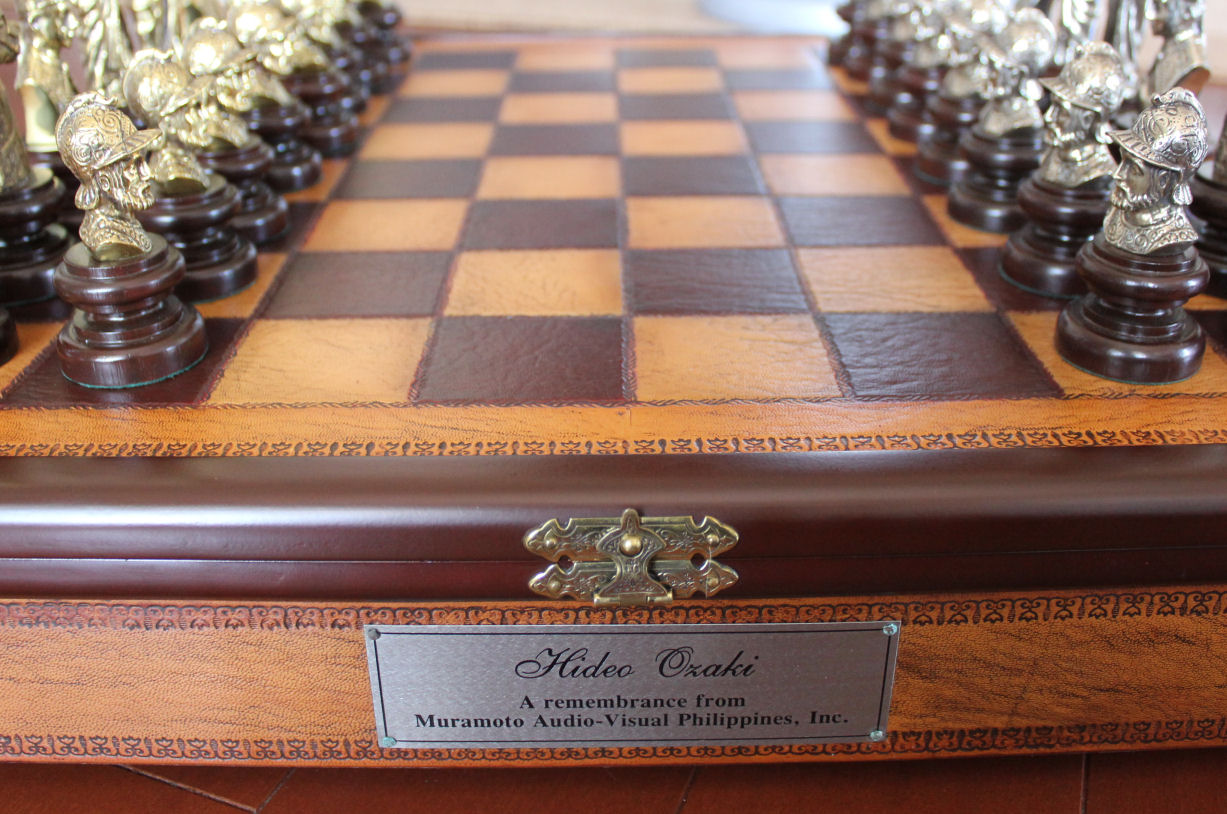 重厚な革張りのチェス盤と金属製の駒